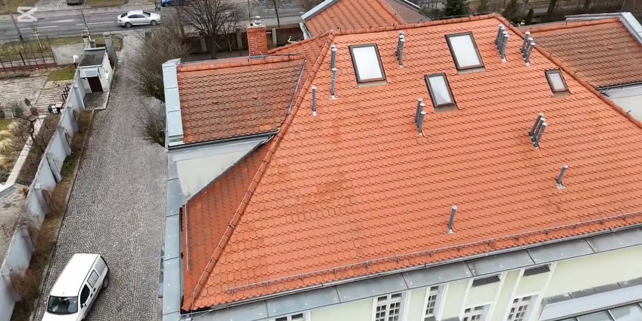Dach kryty ceglastą dachówką ceramiczną z oknami dachowymi, ujęcie z drona, realizacja Bil-Fach